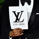 An unidentified guest holds a sign honoring Abloh’s work as creative director of Louis Vuitton menswear.